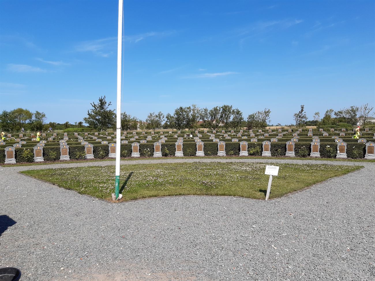 Begraafplaats met hagen, gras en herdenkingsstenen